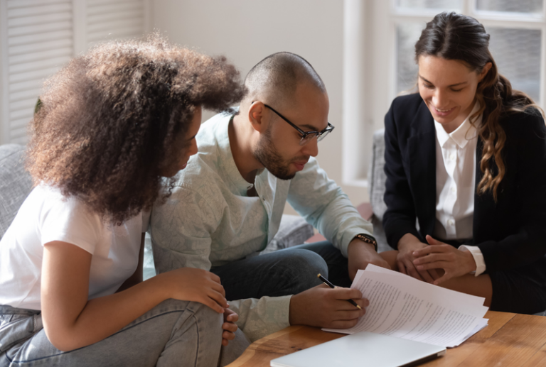 Image is of an advisor speaking with a couple about a prenuptial agreement