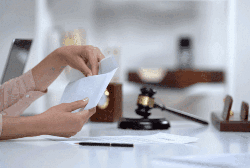 Image is of someone opening an envelope of money, concept of whether or not someone will have to pay alimony in Tennessee