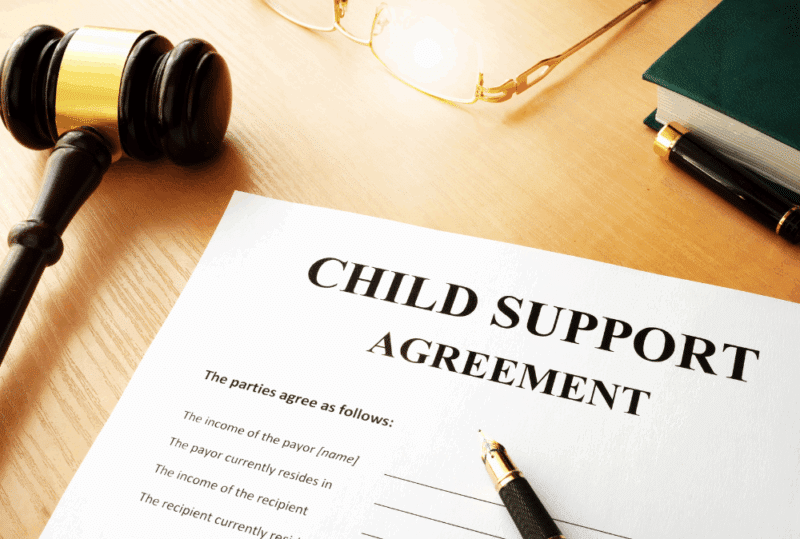 Image is of a paper form that reads 'child support agreement' on a table next to a pen and a judge's gavel, concept of what happens if you don't pay child support in Franklin, Tennessee
