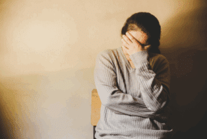 Image is of an upset woman with her head in his hands, concept of how to divorce a missing spouse in Tennessee