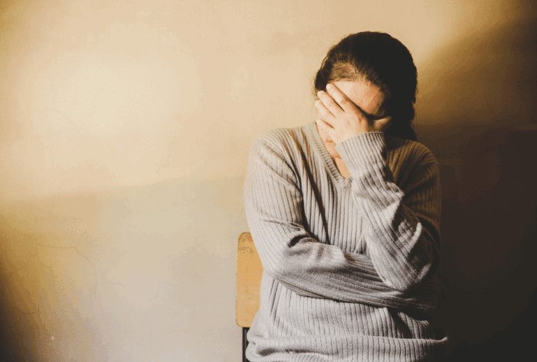 Image is of an upset woman with her head in his hands, concept of how to divorce a missing spouse in Tennessee