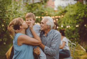 Image is of grandparents carrying their young grandson, grandmother kissing the child on the cheek, concept of grandparents visitation rights after divorce in Franklin