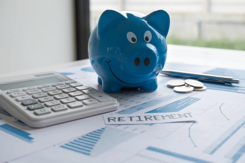 Blue piggy bank with calculator and coins.