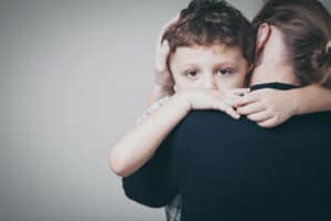 Mother holding child showing emotional impact of relocation on child custody in Franklin.