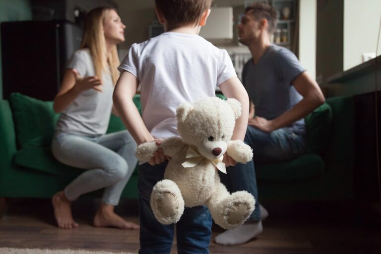 Child holding teddy bear while parents argue representing emotional challenges in shared custody schedules