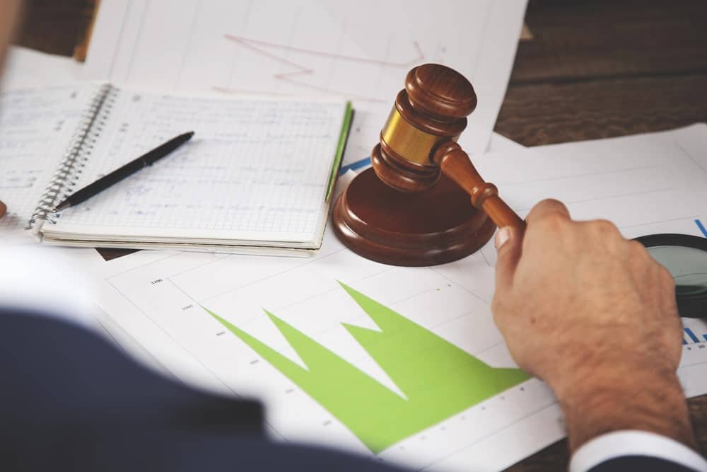 Image is of a judge’s gavel resting on financial charts and documents, representing business valuation issues in a Tennessee divorce.