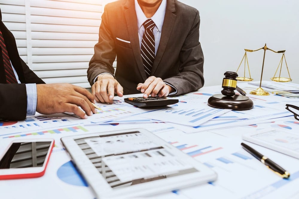 Image is of professionals analyzing business revenue charts and legal documents, showing asset division considerations in a Tennessee divorce.