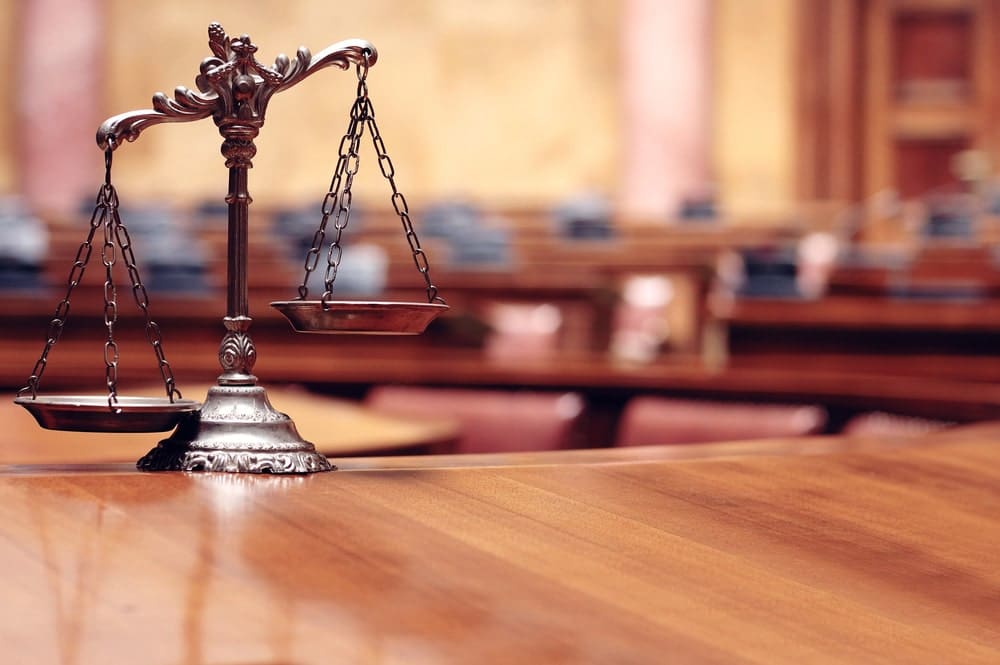 Image is of scales of justice placed on a courtroom table, representing fairness and legal standards applied in Tennessee custody hearings.