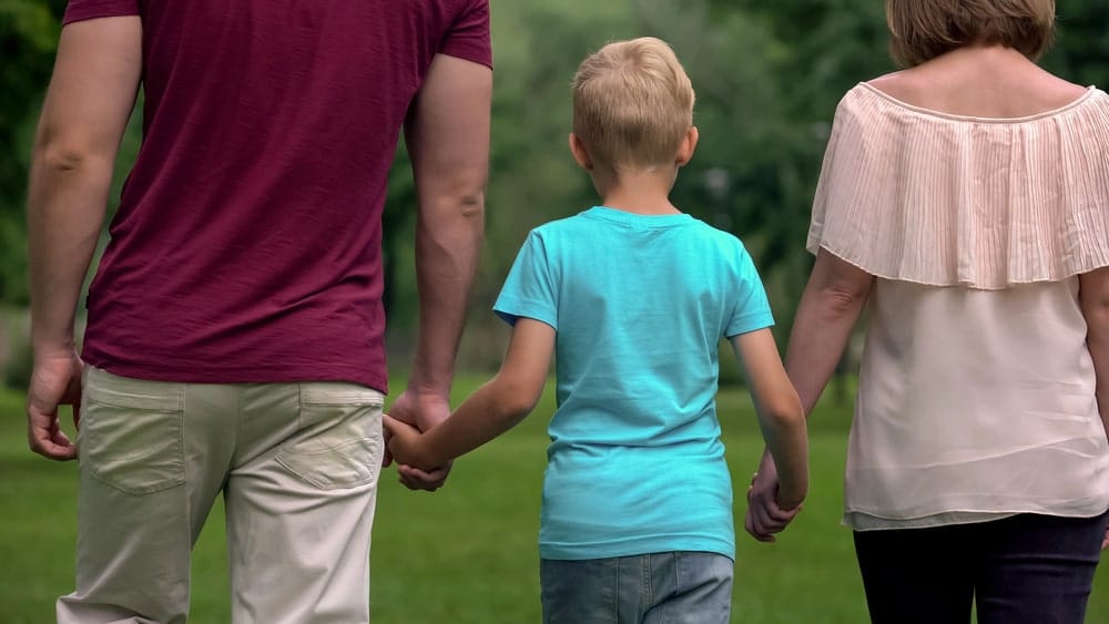 Image is of a mother and father walking with their child outdoors, illustrating child custody rights and the importance of parental involvement in Franklin, Tennessee custody cases