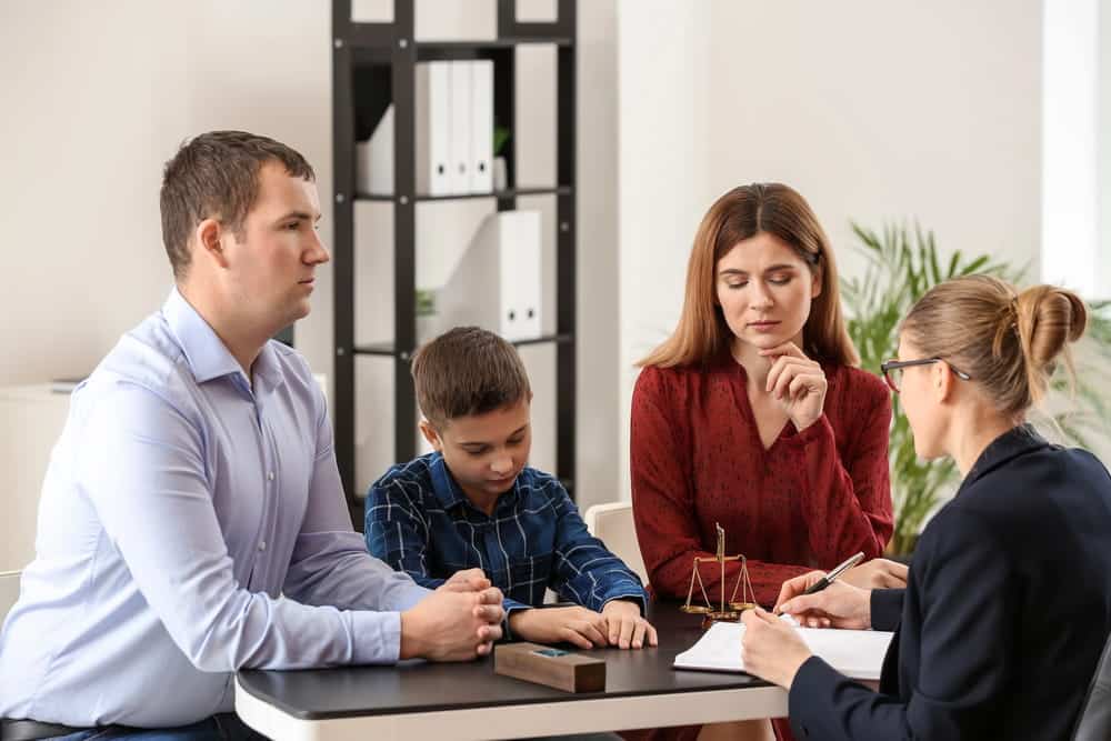 Image is of parents and child sitting with attorney during legal consultation, concept of divorce decree in Tennessee