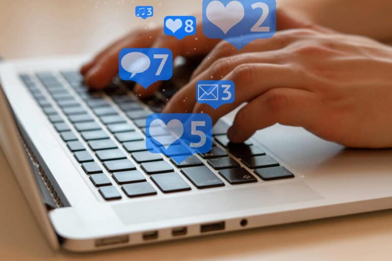 Image is of hands typing on a laptop with social media notifications, showing online activity impact on divorce cases in Franklin
