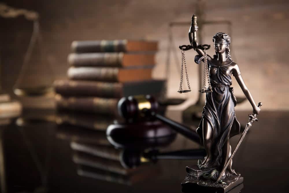 Image is of a Lady Justice statue with scales and gavel, concept of custody rights after divorce and how courts decide parenting responsibilities