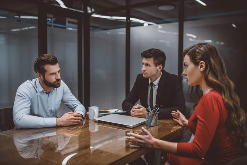 Image is of two parents meeting with attorneys at a conference table, discussing issues related to a parenting plan in Franklin.