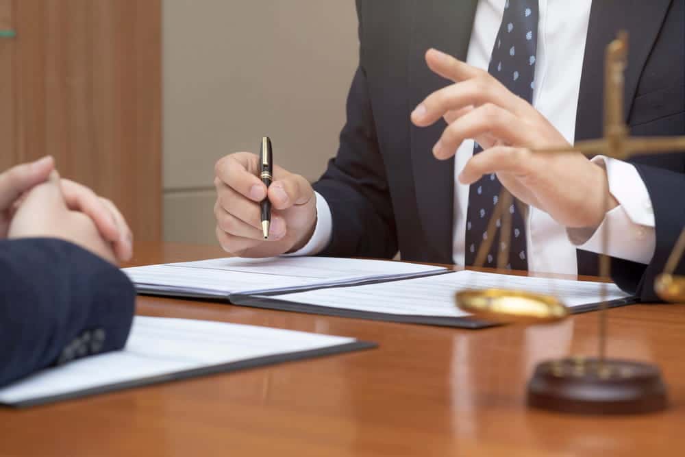 Image is of a lawyer discussing documents with a client, representing legal guidance during a school choice dispute in custody cases