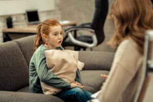 Image is of a young child speaking with an adult in a calm setting, concept of supervised visits in Franklin custody cases