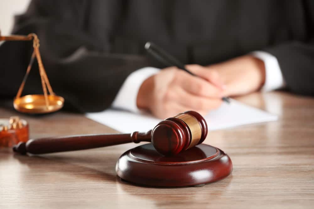 Image is of a judge’s gavel on a desk with a legal professional writing, concept of court decisions in Franklin custody cases