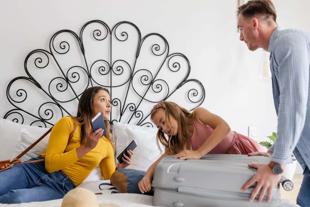 Image is of parents and a child arguing while packing luggage in a bedroom, concept of holiday custody conflicts during divorce in Franklin.