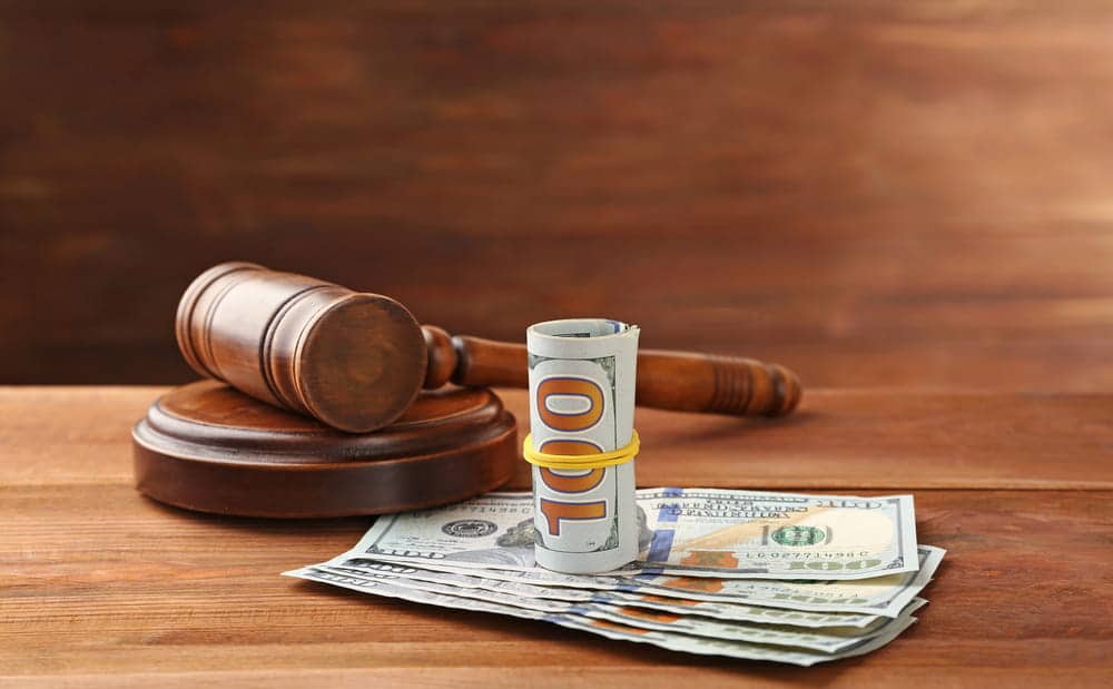 Image is of a judge's gavel placed beside cash, concept of divorce in Tennessee and the legal division of marital debt and financial obligations.