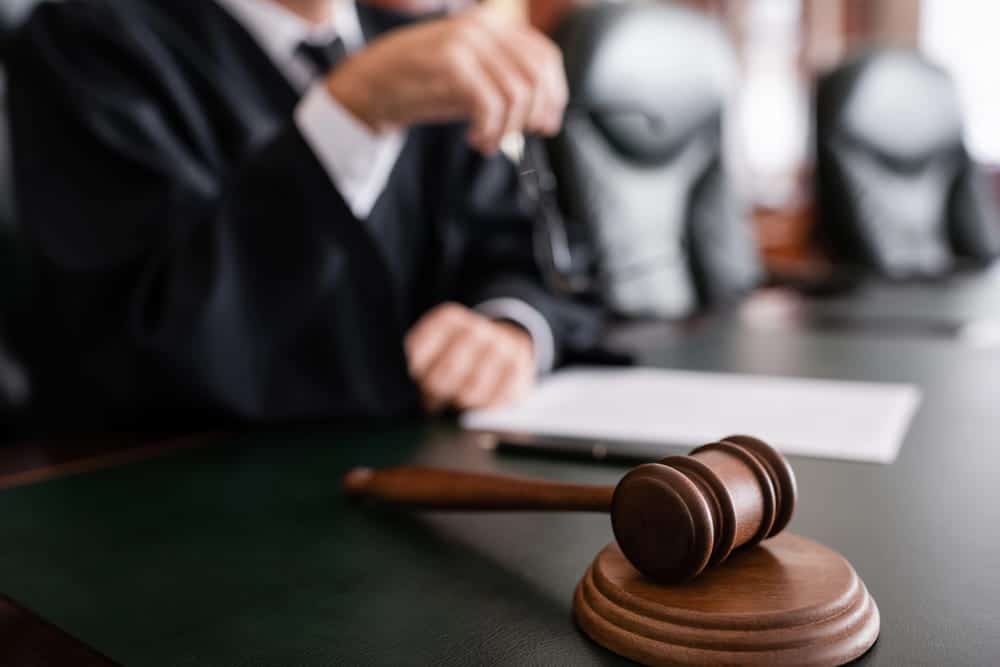 Image is of a judge seated behind a gavel, concept of court decisions affecting a divorce settlement.