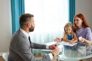 Image is of a parent and child meeting with an attorney in an office, concept of custody modification.